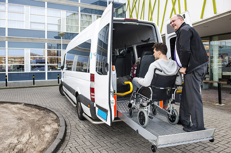 man loading passenger inside a wheelchair accessible van